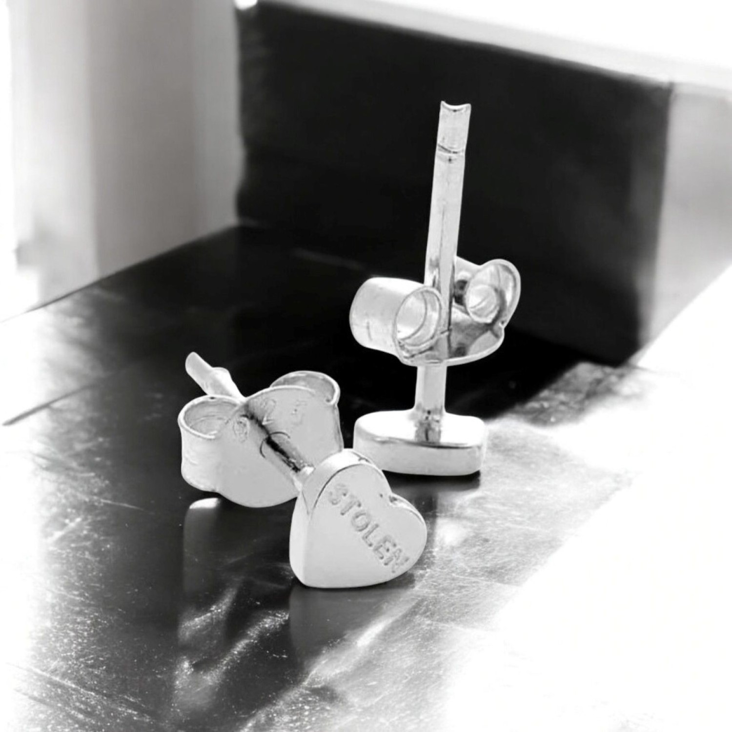 Tiny Stolen Heart Earrings – Stolen Girlfriends Club Jewellery Tiny Stolen Heart Earrings by Stolen Girlfriends Club Jewellery | A pair of heart-shaped stud earrings with the word 'STOLEN' engraved on the front of each heart.