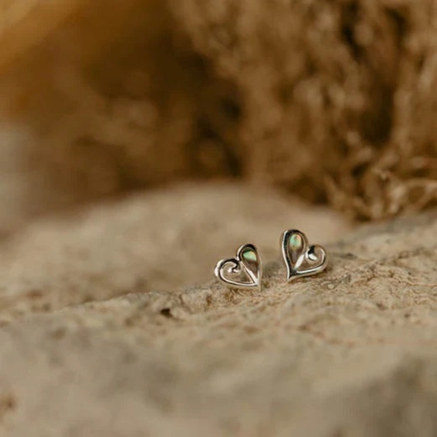 Evolve Mini Heart Paua Stud Earrings Close-up of Evolve Mini Heart Paua Stud Earrings featuring a silver heart design with vibrant paua shell accents.